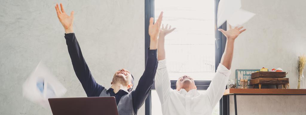 Content writers with laptops celebrating