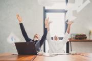 Content writers with laptops celebrating